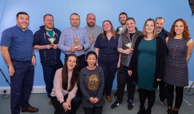 agency staff posing with trophys and awards
