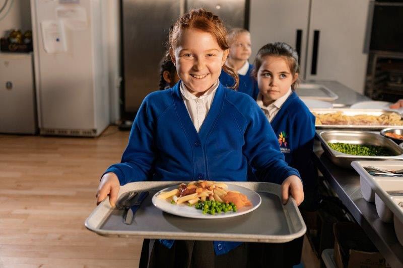 schoolgirl holding a dinner tray wearing school uniform